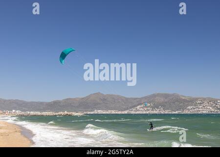 In Empuriabrava, Costa Brava, Provinz Girona, Katalonien, Spanien, wird ein Kiteboarder bei starkem Onshore-Wind von einem Starkdrachen über das Wasser gezogen. Kiteb Stockfoto