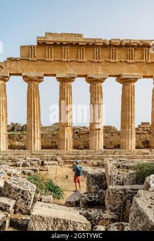 Akropolis von Selinunte, Sizilien, Italien.Mann Reisende genießen Blick auf die Ruinen von Wohn-und Geschäftsgebäuden in der antiken griechischen Stadt Selinus.Summe Stockfoto