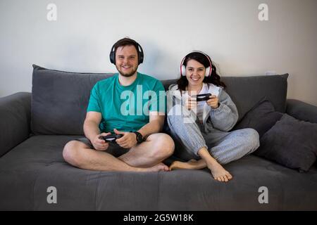 Paar spielen Videospiele zusammen sitzen auf dem Sofa Couch Stockfoto