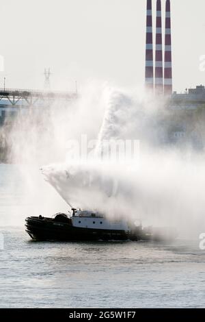 Schlepper mit Feuerlöschkanonen, um Auf Wiedersehen zu RMS Queen Mary 2 und Queen Elizabeth zu sagen, die Halifax Hafen Kanada verlassen Stockfoto