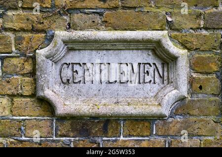 Ein aufwändiges Schild für die Toilette an einer externen Ziegelwand Stockfoto