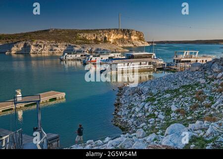 Boote, die am Yachthafen in der Nähe von Rough Canyon Cliffs, Amistad Reservoir, Sonnenuntergang, in der Nähe von Del Rio, Texas, USA Stockfoto