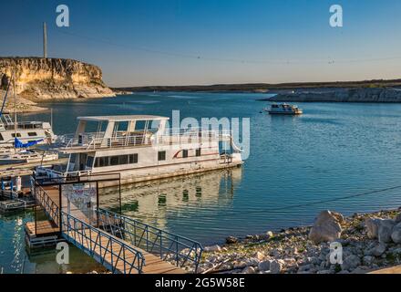 Boote, die am Yachthafen in der Nähe von Rough Canyon Cliffs, Amistad Reservoir, Sonnenuntergang, in der Nähe von Del Rio, Texas, USA Stockfoto