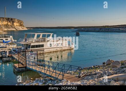 Boote, die am Yachthafen in der Nähe von Rough Canyon Cliffs, Amistad Reservoir, Sonnenuntergang, in der Nähe von Del Rio, Texas, USA Stockfoto