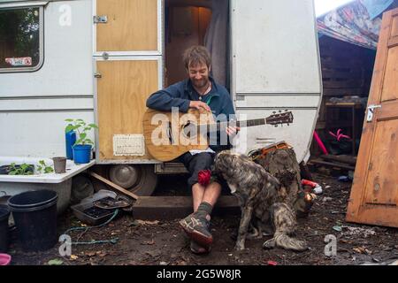 Wendover, Buckinghamshire, Großbritannien. Juni 2021. Ein Protestler und sein Hund. Der Wendover Aktiver Widerstand gegen das W.A.R-Protestlager HS2 im Wald bei Wendover auf der A413, wo Stop HS2-Demonstranten leben. HS2 haben gegenüber dem Lager auf der Road Barn Farm eine riesige Baumfläche gefällt. HS2 wird auf dem Gelände eine Bentonitfabrik errichten und Waldflächen im Gebiet Wendover für die umstrittene Hochgeschwindigkeitsbahn HS2 von London nach Birmingham zerstören. Quelle: Maureen McLean/Alamy Stockfoto