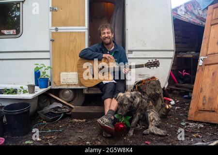 Wendover, Buckinghamshire, Großbritannien. Juni 2021. Ein Protestler und sein Hund. Der Wendover Aktiver Widerstand gegen das W.A.R-Protestlager HS2 im Wald bei Wendover auf der A413, wo Stop HS2-Demonstranten leben. HS2 haben gegenüber dem Lager auf der Road Barn Farm eine riesige Baumfläche gefällt. HS2 wird auf dem Gelände eine Bentonitfabrik errichten und Waldflächen im Gebiet Wendover für die umstrittene Hochgeschwindigkeitsbahn HS2 von London nach Birmingham zerstören. Quelle: Maureen McLean/Alamy Stockfoto