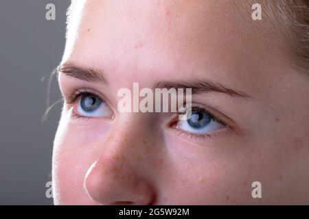 Nahaufnahme der blauen Augen einer kaukasischen Geschäftsfrau, isoliert auf grauem Hintergrund Stockfoto