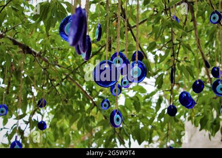 Blaue, böse Augenperlen hingen an einem Baum Stockfoto