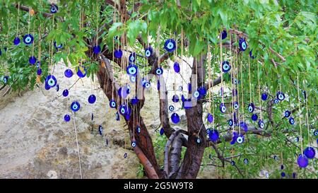 Blaue, böse Augenperlen hingen an einem Baum Stockfoto