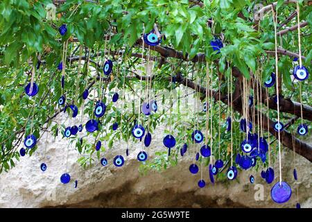 Blaue, böse Augenperlen hingen an einem Baum Stockfoto