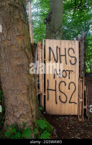 Wendover, Buckinghamshire, Großbritannien. Juni 2021. Eine NHS nicht HS2-Botschaft im Lager. Der Wendover Aktiver Widerstand gegen das W.A.R-Protestlager HS2 im Wald bei Wendover auf der A413, wo Stop HS2-Demonstranten leben. HS2 haben gegenüber dem Lager auf der Road Barn Farm eine riesige Baumfläche gefällt. HS2 wird auf dem Gelände eine Bentonitfabrik errichten und Waldflächen im Gebiet Wendover für die umstrittene Hochgeschwindigkeitsbahn HS2 von London nach Birmingham zerstören. Quelle: Maureen McLean/Alamy Stockfoto