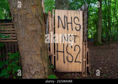 Wendover, Buckinghamshire, Großbritannien. Juni 2021. Eine NHS nicht HS2-Botschaft im Lager. Der Wendover Aktiver Widerstand gegen das W.A.R-Protestlager HS2 im Wald bei Wendover auf der A413, wo Stop HS2-Demonstranten leben. HS2 haben gegenüber dem Lager auf der Road Barn Farm eine riesige Baumfläche gefällt. HS2 wird auf dem Gelände eine Bentonitfabrik errichten und Waldflächen im Gebiet Wendover für die umstrittene Hochgeschwindigkeitsbahn HS2 von London nach Birmingham zerstören. Quelle: Maureen McLean/Alamy Stockfoto