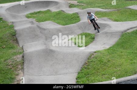 Gerlingen, Deutschland. 30. Juni 2021. Ein Mitarbeiter eines Jugendzentrums fährt mit einem BMX auf einer Pumpstrecke. Pumptracks stehen in vielen Gemeinden ganz oben auf der Liste, nicht nur bei Radfahrern. Die Corona-Pandemie hat den Bauboom erneut angekurbelt. Quelle: Marijan Murat/dpa/Alamy Live News Stockfoto