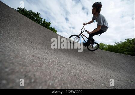 Gerlingen, Deutschland. 30. Juni 2021. Ein Mitarbeiter eines Jugendzentrums fährt mit einem BMX auf einer Pumpstrecke. Pumptracks stehen in vielen Gemeinden ganz oben auf der Liste, nicht nur bei Radfahrern. Die Corona-Pandemie hat den Bauboom erneut angekurbelt. Quelle: Marijan Murat/dpa/Alamy Live News Stockfoto