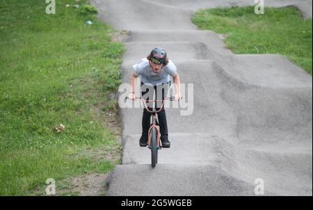 Gerlingen, Deutschland. 30. Juni 2021. Ein Mitarbeiter eines Jugendzentrums fährt mit einem BMX auf einer Pumpstrecke. Pumptracks stehen in vielen Gemeinden ganz oben auf der Liste, nicht nur bei Radfahrern. Die Corona-Pandemie hat den Bauboom erneut angekurbelt. Quelle: Marijan Murat/dpa/Alamy Live News Stockfoto