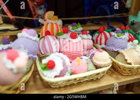 Gestrickte Cupcakes in verschiedenen Farben auf einem Ladenregal Stockfoto
