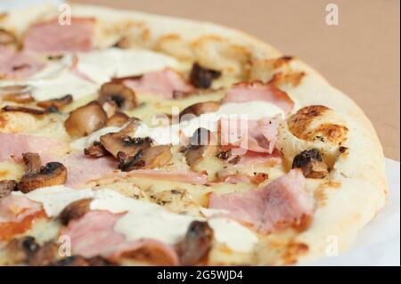 Pizza mit Schinken, Pilzen und Käse Makro-Nahaufnahme Stockfoto