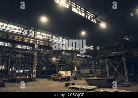 Industriegebäude im Inneren. Innenraum der metallurgischen Anlage. Große dunkle Fabrik Werkstatt. Stockfoto