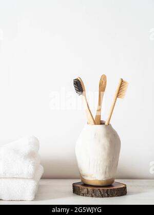 Set aus hölzernen Bambus-Zahnbürsten aus Keramikglas. Vorderansicht Stockfoto