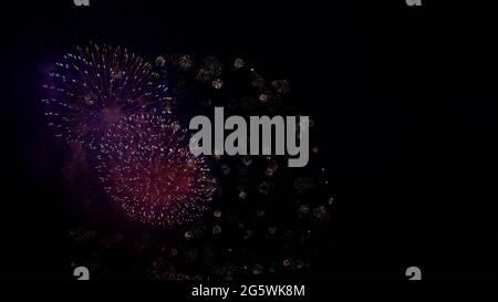 Buntes Feuerwerk in verschiedenen Farben über dem Nachthimmel, Real Fireworks auf Deep Black Background Sky auf Fireworks Festivalshow vor dem Unabhängigkeitstag Stockfoto