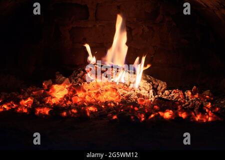 Holzscheite brennen im Ofen aus. Kohlen und Flammen im Kamin. Stockfoto