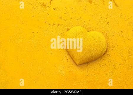 3 dimensionale Herzform, die von gelber Farbe bespritzt und mit trockenem Pigment bestreut wird. Die verwendete Farbe ist Gerstaecker Creativ Pigmente (Gerstaecker Cr Stockfoto