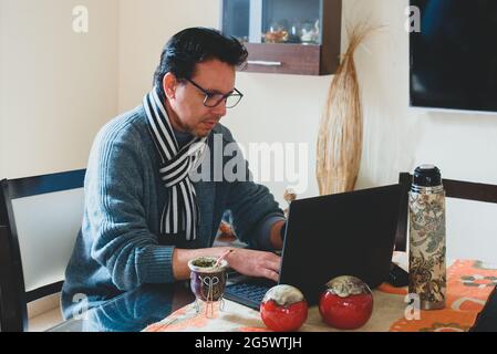 Hombre escribiendo en la mesa de madera planificando el analisis de negocio con la Laptop, venta,compra, Internet desde casa. Stockfoto