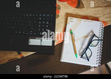 Hombre escribiendo en la mesa de madera planificando el analisis de negocio con la Laptop, venta,compra, Internet desde casa. Stockfoto