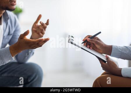 Professionelles psychologisches Hilfekonzept. Nicht erkennbarer schwarzer Mann, der im Büro mit einem Psychotherapeuten spricht, Nahaufnahme Stockfoto