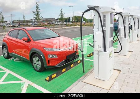 Elektrische Auto-Parkplatz Laden an einem der Electric Highway Ladegeräte klimaschutzfreundlich neue MOTO Rugby Service Station M6 Autobahn England Großbritannien Stockfoto