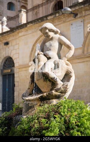 Noto, Syrakus, Sizilien, Italien. Antiker Steinbrunnen auf der Piazza dell'Immacolata mit der geschnitzten Figur eines Jungen, der auf einem Delphin reitet. Stockfoto