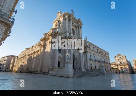 Ortygia, Syrakus, Sizilien, Italien. Blick über die Piazza del Duomo auf die reich verzierte barocke façade der Kathedrale, Sonnenaufgang. Stockfoto