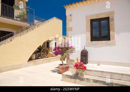 Noto, Syrakus, Sizilien, Italien. Blick auf den sonnendurchfluteten Innenhof des La Corte del Sole, einer ehemaligen masseria aus dem 19. Jahrhundert, die heute ein Boutique-Hotel ist. Stockfoto