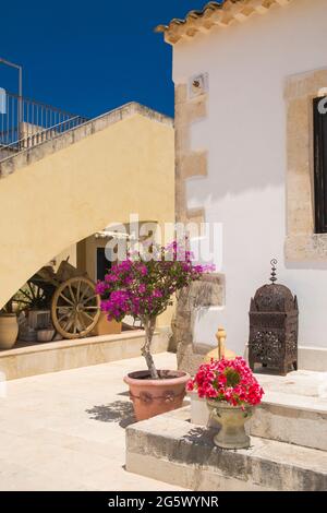 Noto, Syrakus, Sizilien, Italien. Blick auf den sonnendurchfluteten Innenhof des La Corte del Sole, einer ehemaligen masseria aus dem 19. Jahrhundert, die heute ein Boutique-Hotel ist. Stockfoto