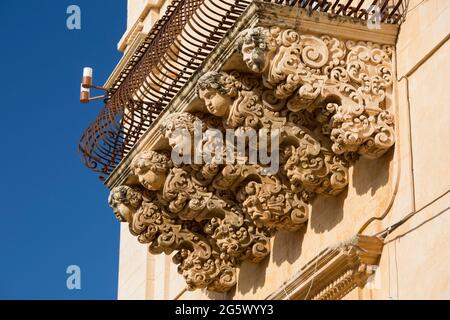 Noto, Syrakus, Sizilien, Italien. Fein geschnitzte Steinfiguren, die einen dekorativen Balkon auf der barocken façade des Palazzo Nicolaci di Villadorata stützen. Stockfoto