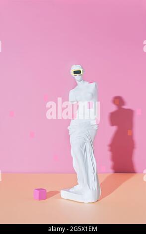 Kreatives Layout mit der VR-Brille-Skulptur auf einer antiken Venus auf dem farbenfroh rosa Hintergrund. Neue Technologie digitale Gadget. Konzeptkunst mit einem m Stockfoto