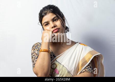 Isoliert auf weißem Hintergrund eine indische Hausfrau trägt Saree in nachdenklichen und gelangweilten Look Stockfoto