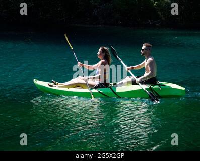 Junge Leute kühlen sich an einem heißen Sommertag in den Oregon Cascades in einem Kajak für zwei Personen auf dem Clear Lake ab. Stockfoto