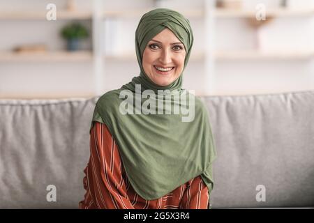 Porträt Einer Lächelnden Älteren Muslimischen Dame, Die Zu Hause Hijab Trägt Stockfoto