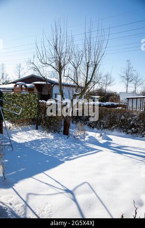 Im Winter ruht ein kleiner schneebedeckter Schottergarten Stockfoto