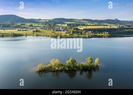 Luftaufnahme über den Rottachsee zum Dorf Petersthal, Insel im See, Allgau, Bayern, Deutschland. Stockfoto