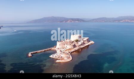 Griechenland, Bourtzi, venezianische Wasserfestung am Eingang des Hafens von Nafplio. Luftdrohnenansicht. Blauer Himmel, gewellter Meereshintergrund. Stockfoto