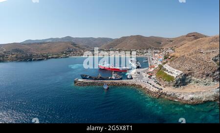 Sommerziel Kea, Insel Tzia, Kykladen, Griechenland. Korissia Port – Luftdrohnenansicht. Schiffe und Boote vertäuten am Hafendock, eine Fähre nähert sich Stockfoto