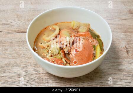 Gekochte Blumenkrabben und Garnelen verbinden Tintenfisch mit Dolly-Fisch in einer thailändischen, würzigen Suppe oder Fisch mit tom Yum auf der Schüssel Stockfoto