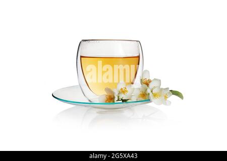 Transparente Tasse grünen Tee mit Jasminblüten isoliert auf weißem Hintergrund Stockfoto