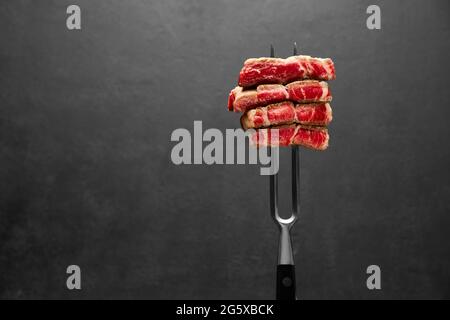 Studioaufnahme von Steak-Scheiben auf einer Fleischgabel Stockfoto