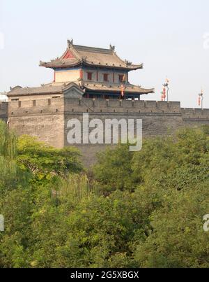 Stadtmauer, Xian, Provinz Shaanxi, China. Die Stadtmauer von Xian ist eine der am besten erhaltenen in China. Wachturm an der Stadtmauer von Xian mit Blick auf Bäume. Stockfoto