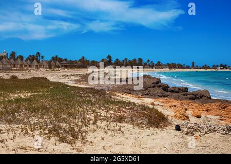 Ein schöner Blick auf die Mittelmeerküste mit Birkenwasser, einem Strand mit weißem Sand und einer grünen Palme. Stockfoto