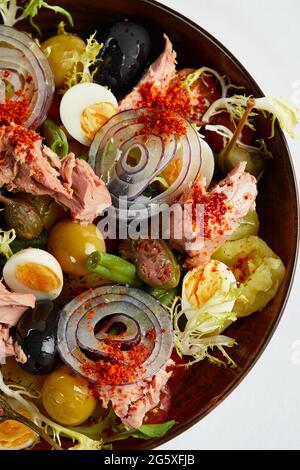 Thunfischsalat mit frischem Gemüse auf weißer Serviette, klassische Nicoise im Vortrag des Autors, Thunfischkonserven mit Masilnas, Zwiebeln und Eiern, Draufsicht Stockfoto
