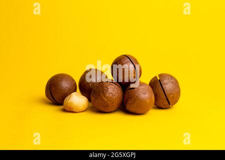 Köstliche und kalorienreiche Macadamianuss auf gelbem Grund. Stockfoto